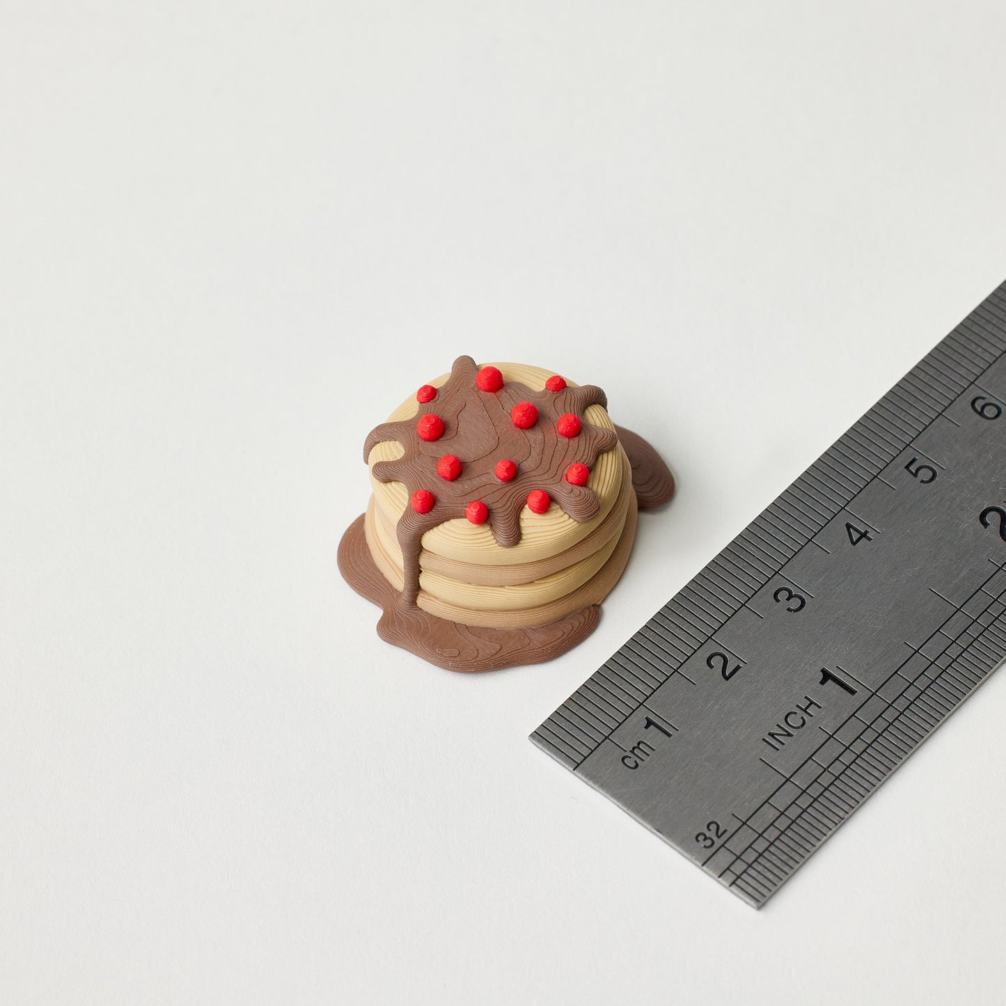 Pancake Topper next to ruler showing size dimensions for guitar pedal footswitch