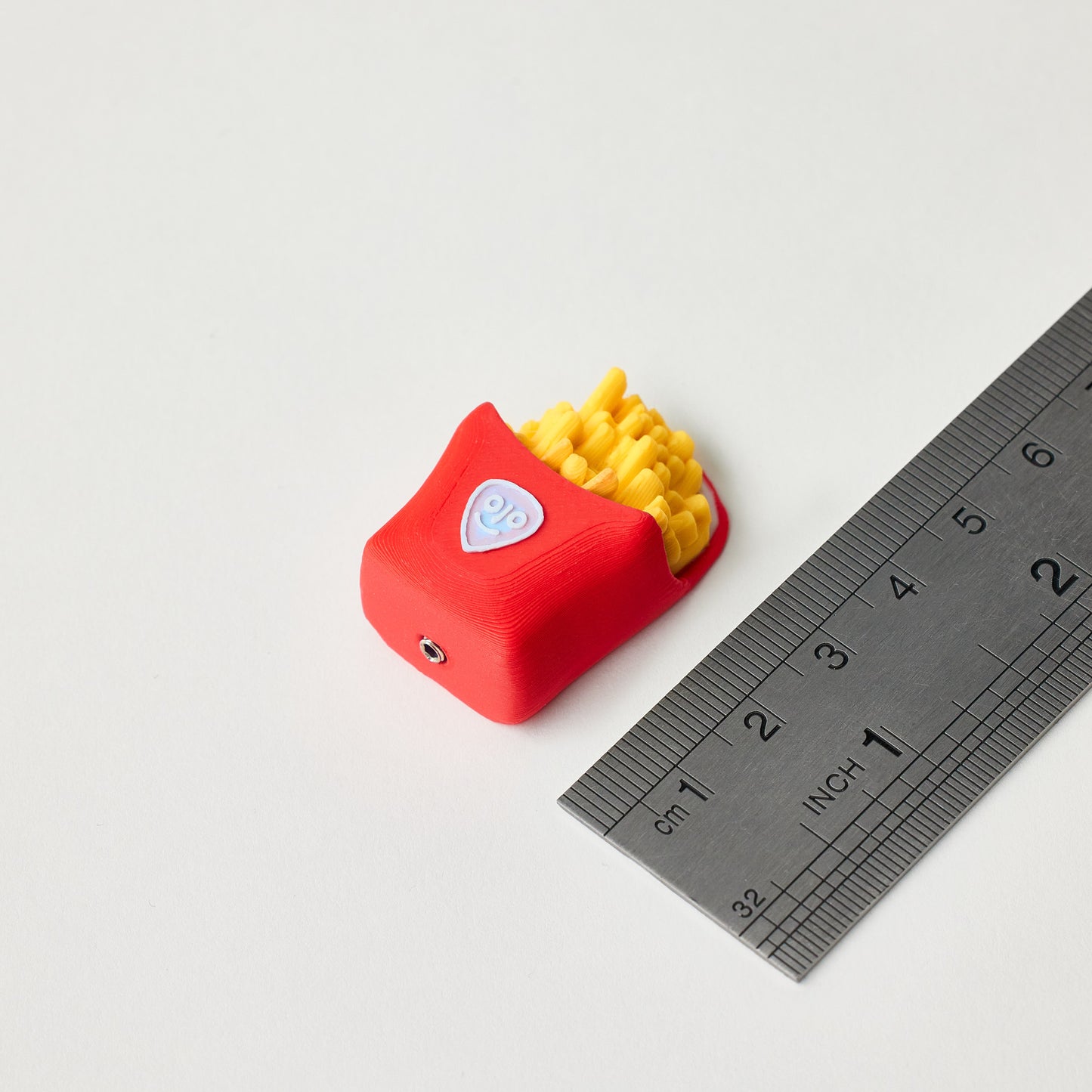 Fries Topper next to ruler showing size dimensions for guitar pedal footswitch
