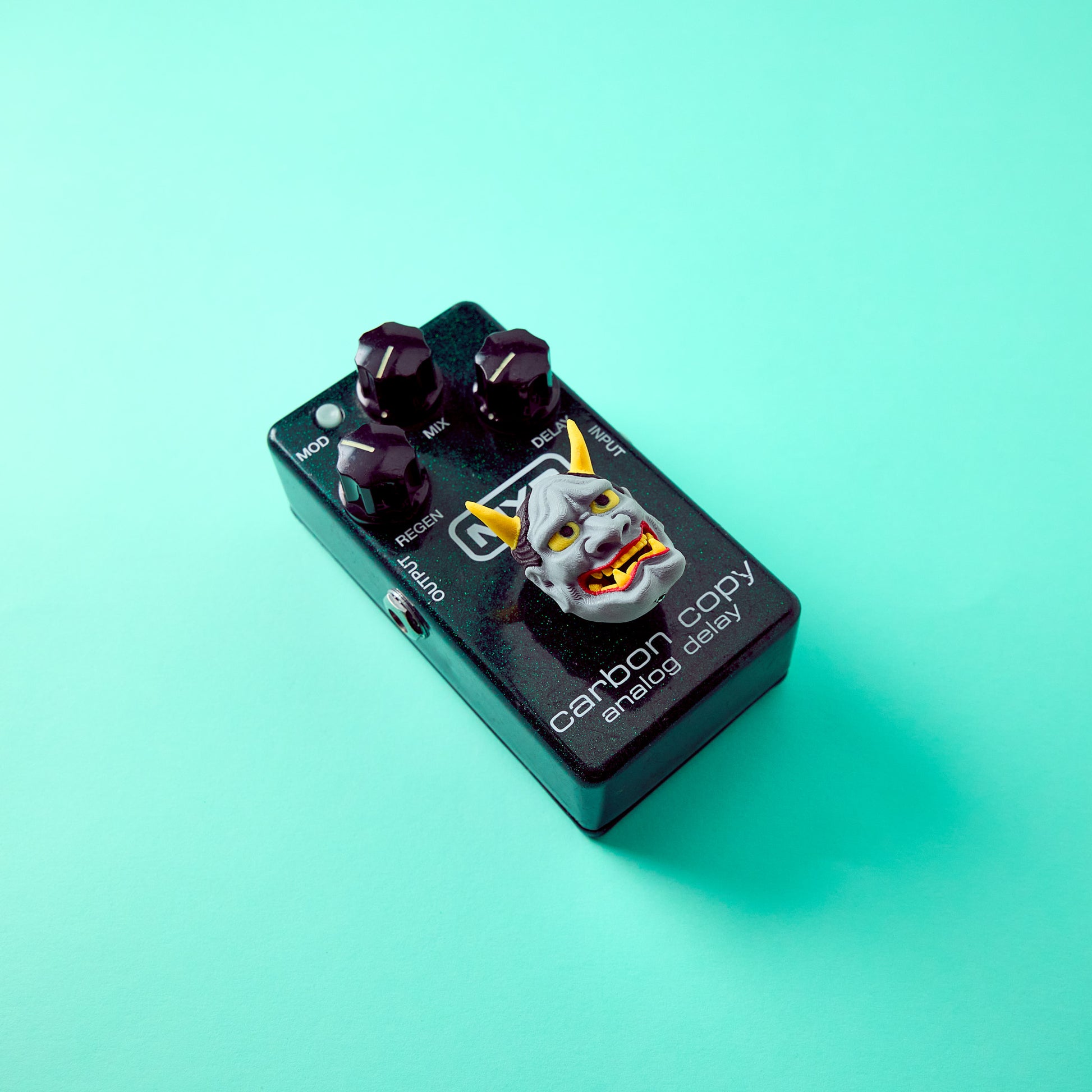 Hannya Topper — Japanese demon mask topper installed on effects pedal forty five degree angle showing horn height for guitar and bass
