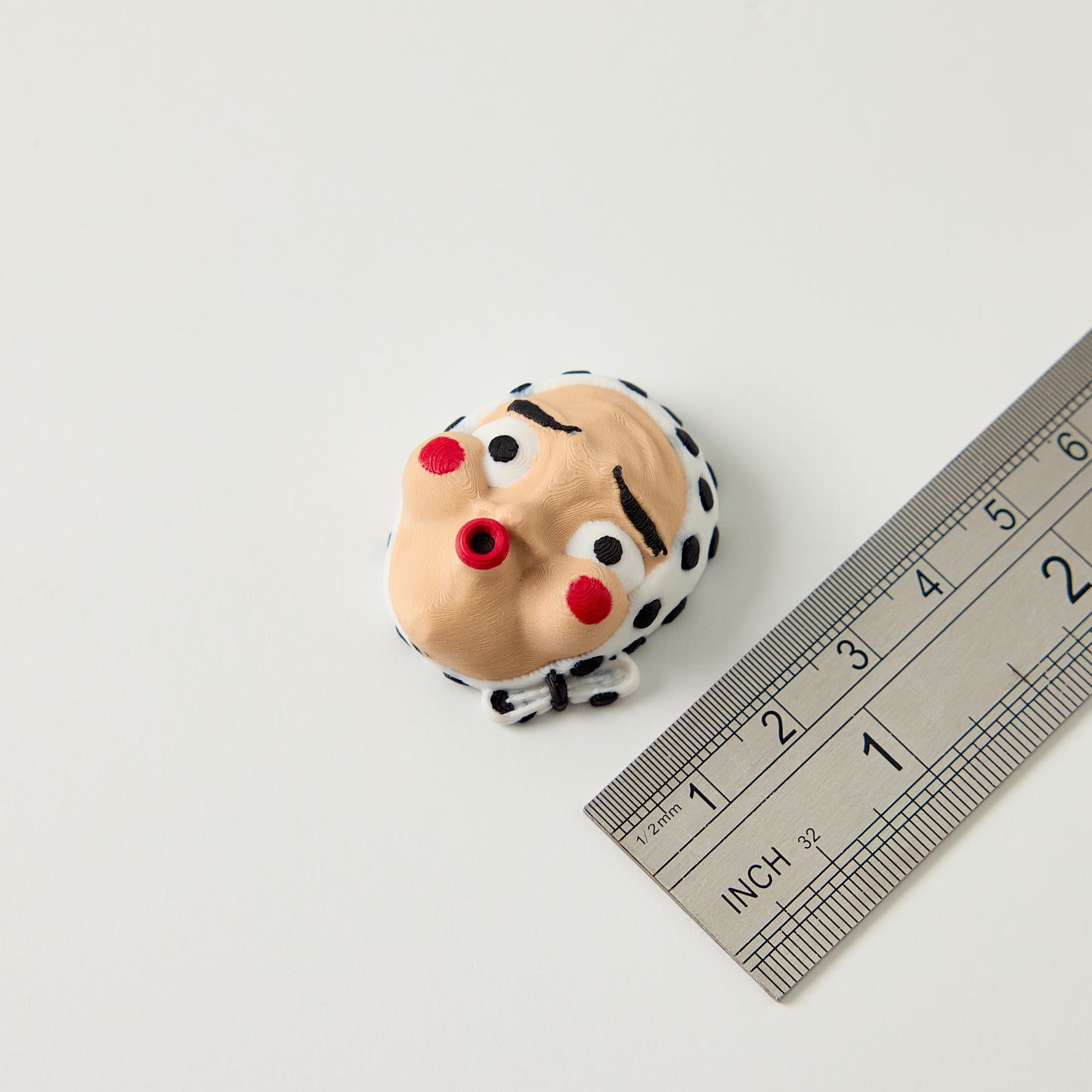 Hyottoko Topper — size reference with ruler showing Japanese folk mask topper dimensions for 10mm guitar effects pedal footswitch