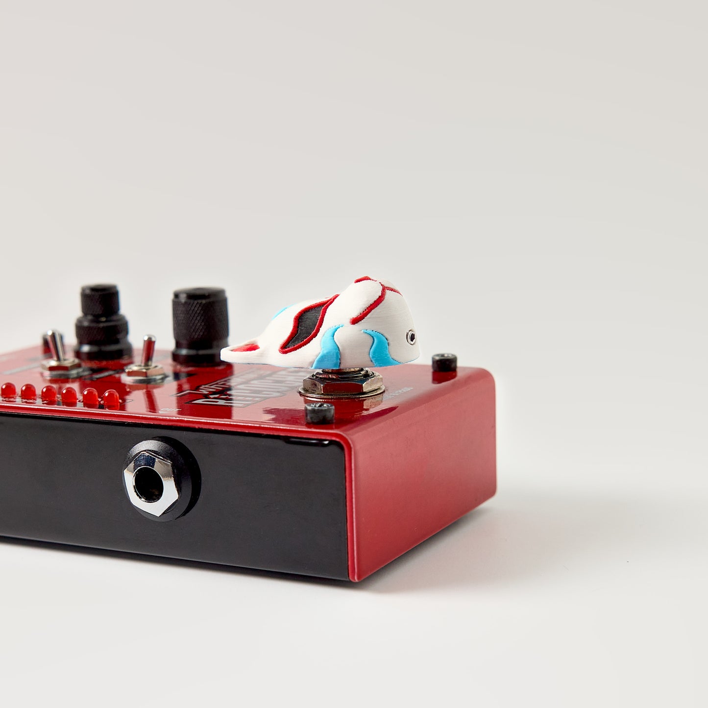 Kitsune Topper — Japanese fox mask installed on dark multi-switch effects pedal top view showing footswitch fit for guitar and bass