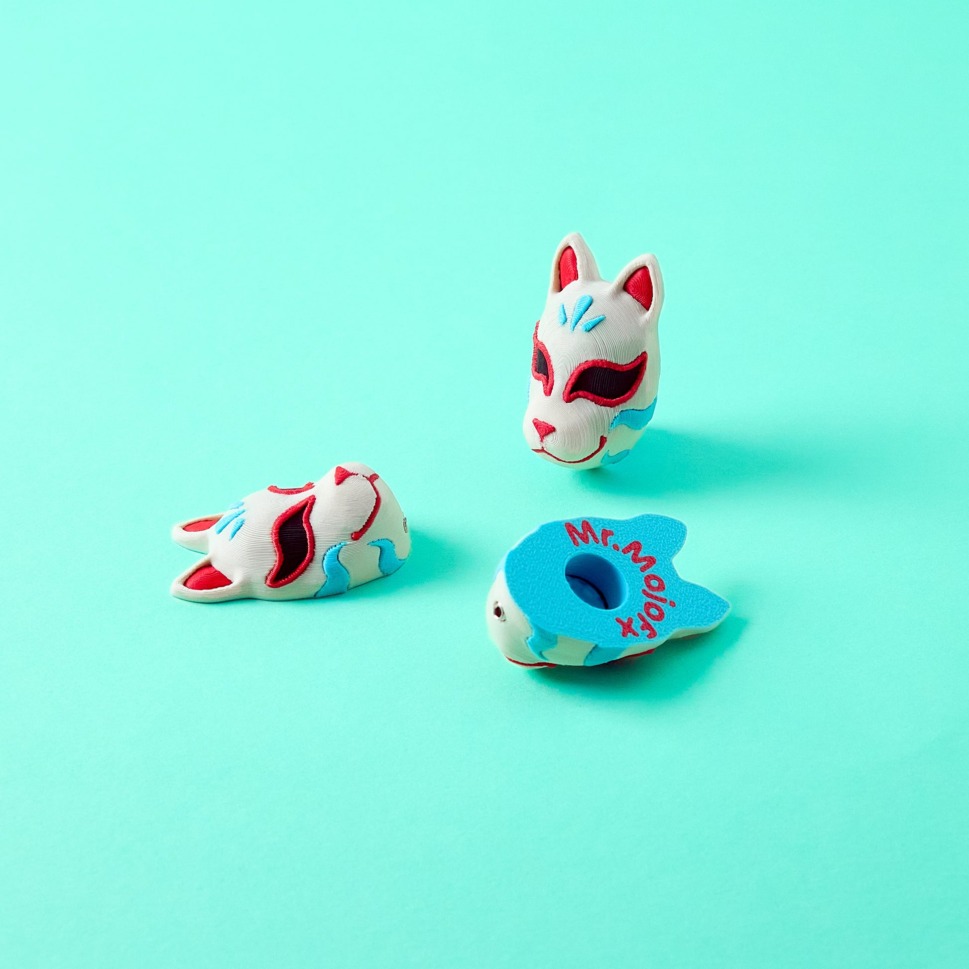 Kitsune Topper — Japanese fox spirit mask pedal switch topper on teal background showing front and back angled views