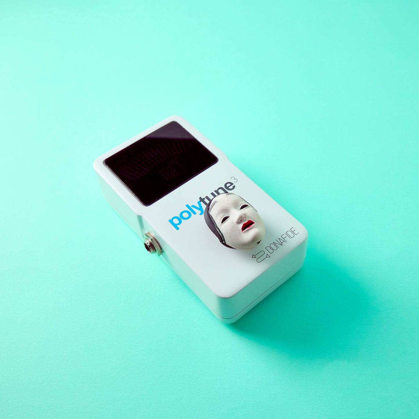 Koomote Topper — Japanese Noh mask topper installed on TC Electronic Polytune effects pedal top angle view for guitar and bass