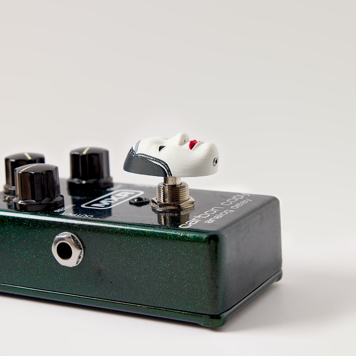 Koomote Topper — Japanese Noh mask installed on dark green multi-switch effects pedal showing topper height and footswitch fit