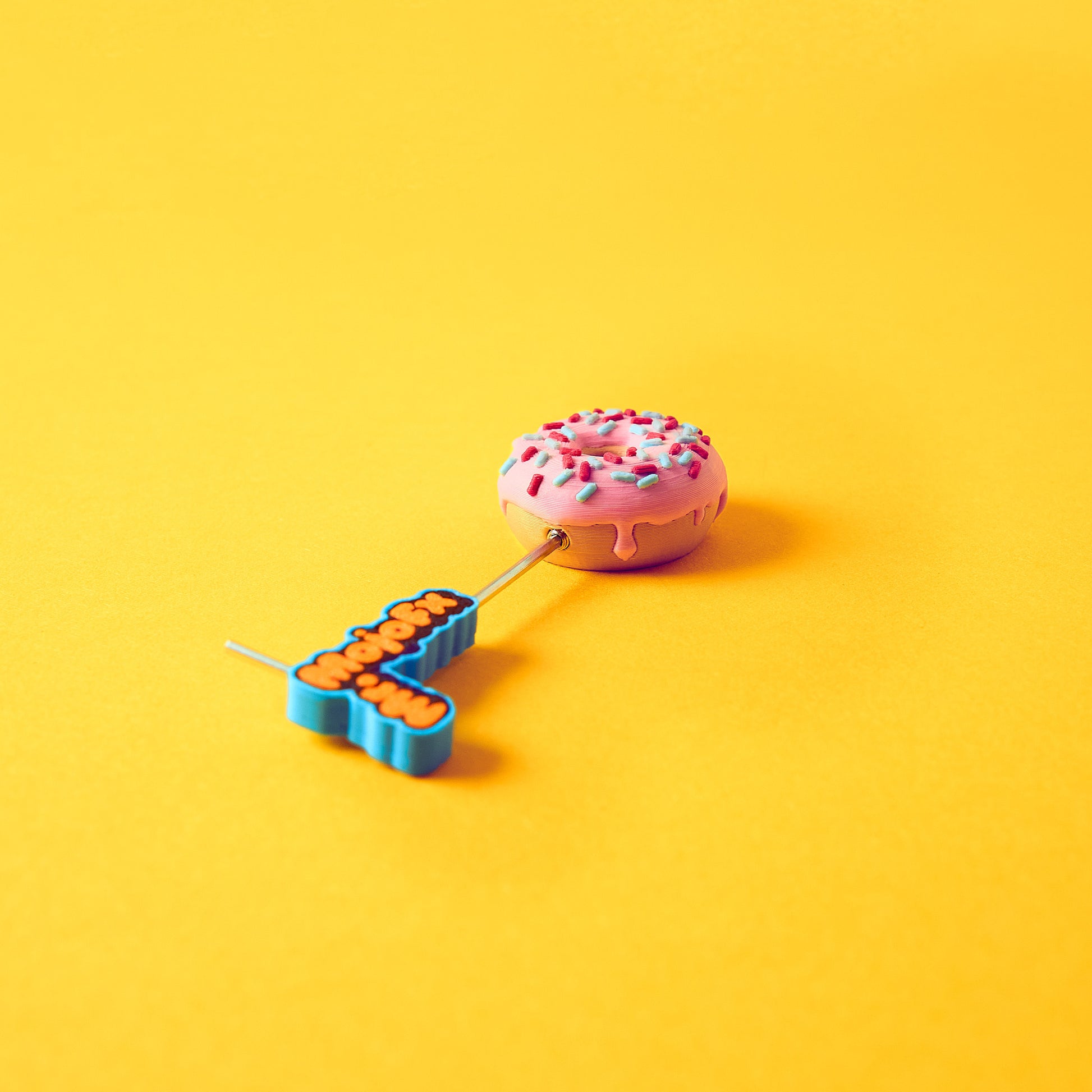 Mr.MojoFx 1.5mm Allen key screwing one Munchies Donut footswitch topper on yellow background