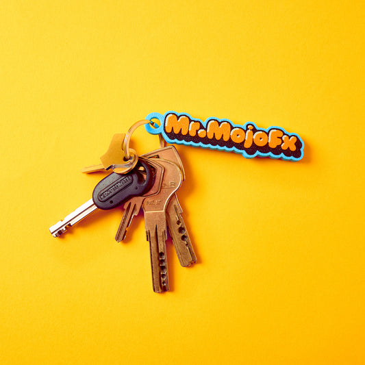 Mr.MojoFx Classic Key Fob on a set of keys — lifestyle shot on yellow background