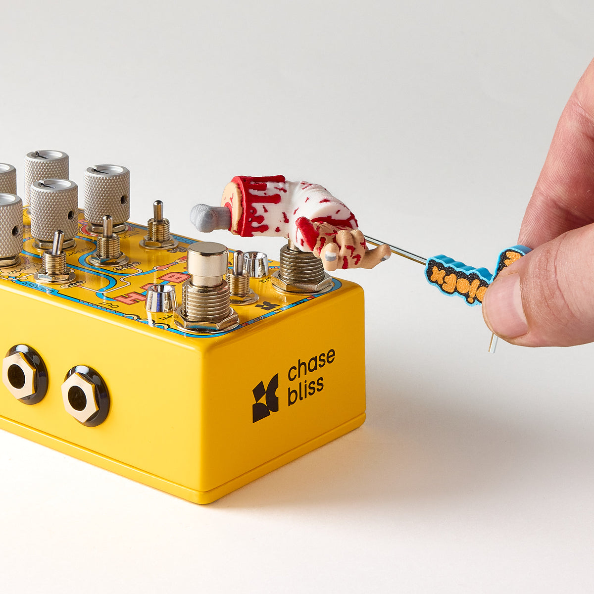 Installing a Mr. MojoFX Dogtown Broken Arm switch topper onto a yellow Chase Bliss Habit guitar pedal using the 1.5mm Allen key