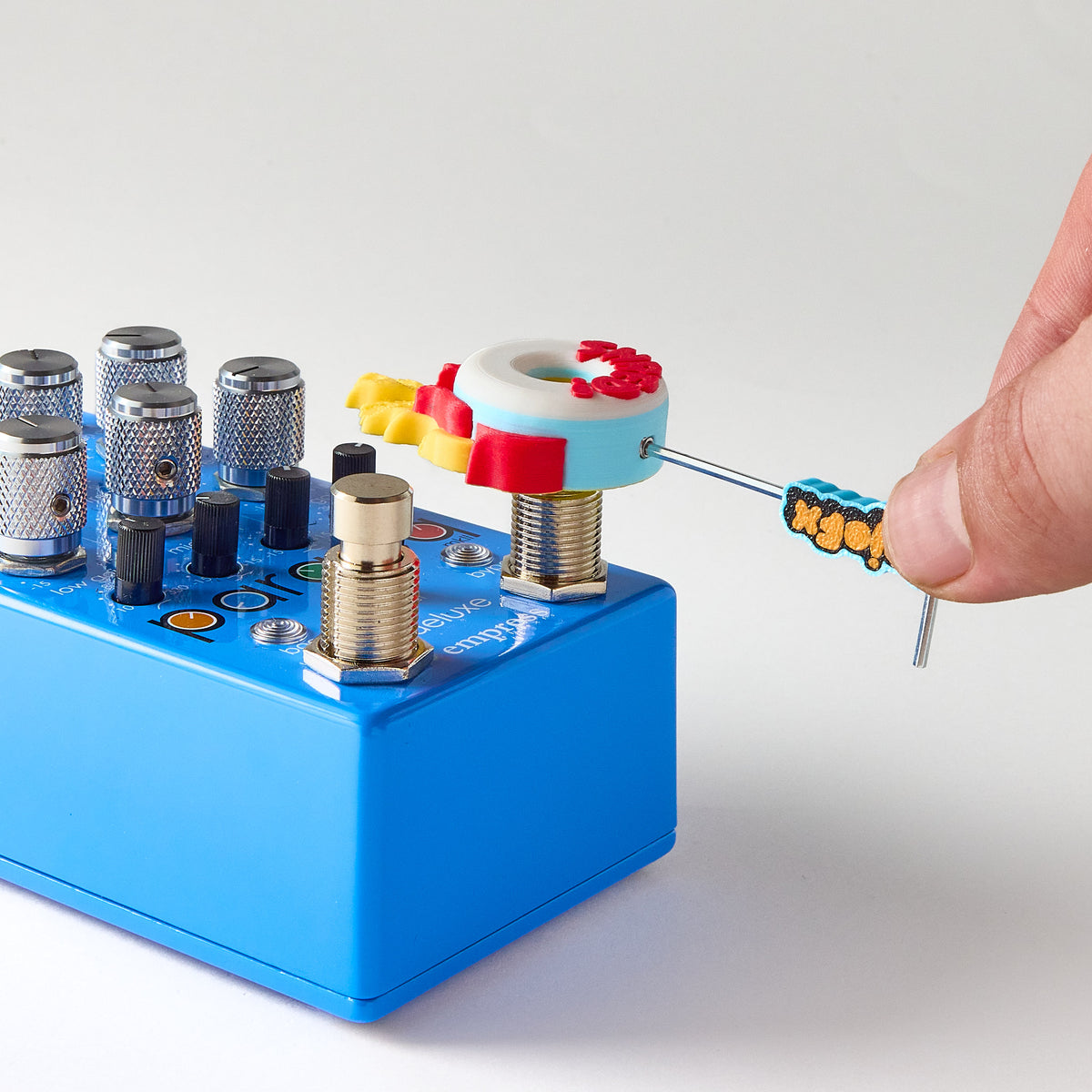 Installing a Mr. MojoFX Dogtown SHRED Skate Wheel switch topper onto a blue empress effects paraeq deluxe II guitar effects pedal using the 1.5mm Allen key