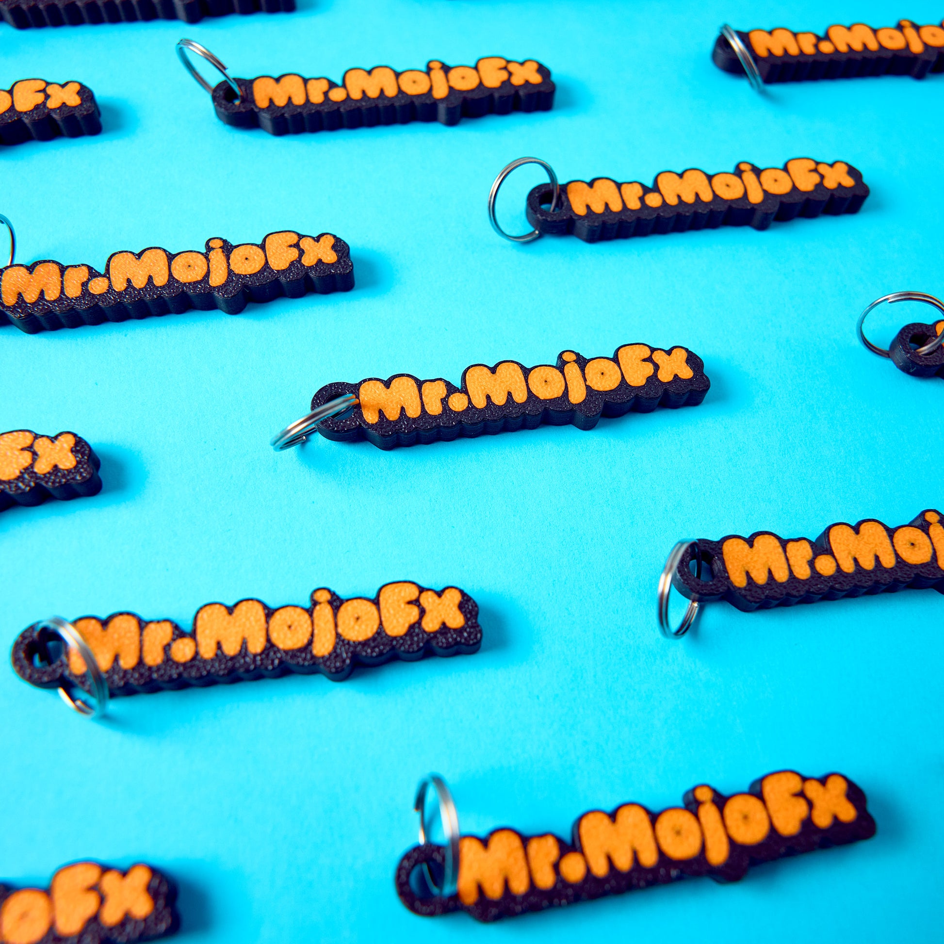Mr.MojoFx mini key fobs — multiple units on teal background