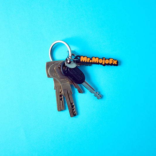 Mr.MojoFx mini key fob attached to a set of keys on teal background