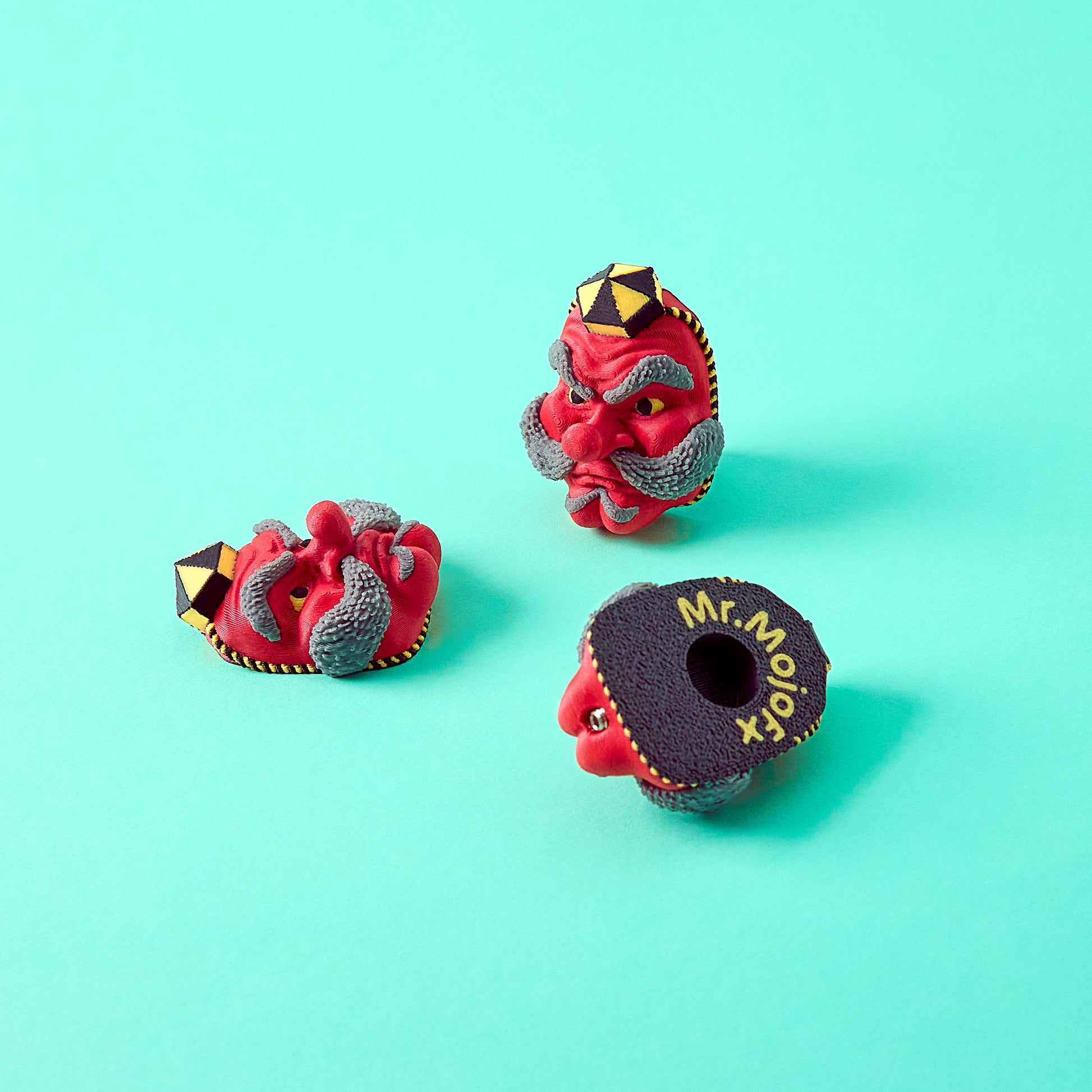 Tengu Topper — Japanese mask pedal switch toppers on teal background showing front, back and side angles